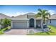 Charming single-story home with a well-maintained front yard, palm tree, and a colorful turquoise front door at 140 Trinity Ridge Cir, Davenport, FL 33897
