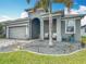 Single-story home featuring a lush front yard with tropical landscaping, a gray exterior, and a covered entryway at 140 Trinity Ridge Cir, Davenport, FL 33897