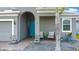 Welcoming front porch with comfortable seating, colorful planters, and a stylish turquoise front door at 140 Trinity Ridge Cir, Davenport, FL 33897