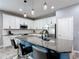 Modern kitchen with white cabinets, granite countertops, stainless steel appliances, and a large island with seating at 140 Trinity Ridge Cir, Davenport, FL 33897