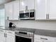 A well-appointed kitchen features white cabinets, stainless steel appliances, and granite countertops at 140 Trinity Ridge Cir, Davenport, FL 33897