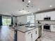 A modern kitchen features a granite island, stainless steel appliances, and white cabinetry at 140 Trinity Ridge Cir, Davenport, FL 33897