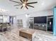 Spacious living room with hardwood floors, ceiling fan, entertainment center and adjacent kitchen at 140 Trinity Ridge Cir, Davenport, FL 33897