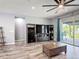 Living room with hardwood floors, ceiling fan, entertainment center, and sliding door to backyard at 140 Trinity Ridge Cir, Davenport, FL 33897