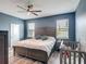 Blue main bedroom with hardwood floors, fan, and a crib next to the bed at 140 Trinity Ridge Cir, Davenport, FL 33897