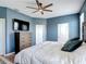 Main bedroom with blue walls, ceiling fan, wood-look flooring, and a large bed at 140 Trinity Ridge Cir, Davenport, FL 33897