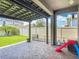 Covered patio with brick flooring, offering a cozy outdoor space with a view of the fenced backyard at 140 Trinity Ridge Cir, Davenport, FL 33897