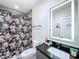 Stylish bathroom with floral shower curtain, illuminated mirror, and modern sink at 1425 Serendipity Ln, Clermont, FL 34714
