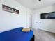 Comfortable bedroom features a single bed, mounted TV, and neutral decor at 1425 Serendipity Ln, Clermont, FL 34714