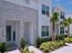 Stylish townhome facade featuring decorative stone, verdant plants, and inviting, well-lit entryways at 1425 Serendipity Ln, Clermont, FL 34714
