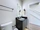 Modern half bathroom with a sleek vanity, illuminated mirror, and stylish black fixtures at 1425 Serendipity Ln, Clermont, FL 34714