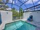 Inviting screened-in pool area with clear blue water and a comfortable lounge chair at 1425 Serendipity Ln, Clermont, FL 34714