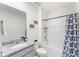 This bathroom features a toilet, sink, granite countertop, bathtub, and shower with a blue and white curtain at 1490 Olive Ct, St Cloud, FL 34771