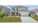 Charming two-story home featuring a well-manicured lawn and a welcoming front porch with seating area at 1490 Olive Ct, St Cloud, FL 34771