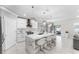 Sleek, modern kitchen with white cabinetry, marble countertops, and a large central island with seating at 1490 Olive Ct, St Cloud, FL 34771