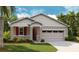 Charming single-Gathering home with a two-car garage, stone accents and well-manicured lawn at 204 Flag Lilly Ln, Umatilla, FL 32784
