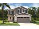 Charming two-story home featuring stone accents, a two-car garage, and beautifully landscaped front yard at 227 Bull Frog Ln, Umatilla, FL 32784