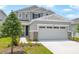 Charming two-story home featuring a neutral color palette, stone accents, manicured landscaping, and an inviting front entrance at 227 Bull Frog Ln, Umatilla, FL 32784