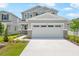Charming two-story home featuring a neutral color palette, stone accents, manicured landscaping, and an inviting front entrance at 227 Bull Frog Ln, Umatilla, FL 32784