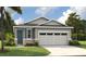 Charming one-story home with stone accents, a two-car garage, and lush landscaping at 231 Bull Frog Ln, Umatilla, FL 32784