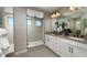 Sleek bathroom with dual vanities, framed mirrors, walk-in shower, and neutral tile at 232 Flag Lilly Ln, Umatilla, FL 32784