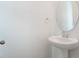 Neat half bathroom featuring a pedestal sink and a round mirror at 232 Flag Lilly Ln, Umatilla, FL 32784