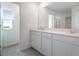 Bathroom featuring dual sinks, white cabinetry, and a large mirror at 232 Flag Lilly Ln, Umatilla, FL 32784