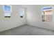 A bright bedroom with three windows providing ample natural light, complimented by neutral walls and carpeting at 232 Flag Lilly Ln, Umatilla, FL 32784