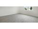 Bright bedroom with hard surface floors, white walls, and a large window overlooking the backyard at 232 Flag Lilly Ln, Umatilla, FL 32784