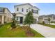 Charming two-story home with a landscaped front yard and a modern gray driveway and garage door at 232 Flag Lilly Ln, Umatilla, FL 32784