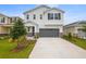 Inviting two-story home with a gray garage door, showcasing a well-manicured lawn and modern design at 232 Flag Lilly Ln, Umatilla, FL 32784