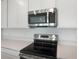 The well-equipped kitchen features stainless steel appliances and white cabinets at 232 Flag Lilly Ln, Umatilla, FL 32784