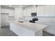 Bright kitchen featuring white cabinetry, stainless steel appliances, a spacious island and gray tile floors at 232 Flag Lilly Ln, Umatilla, FL 32784