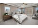 Comfortable bedroom showcasing large bed, ceiling fan, tray ceiling and natural light at 232 Flag Lilly Ln, Umatilla, FL 32784