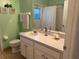 The bathroom features a light green wall with decorative art and a bright vanity with decor at 240 Steamboat Blvd, Davenport, FL 33897