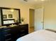 Bedroom with dark wooden dresser and mirror; white linens on bed at 240 Steamboat Blvd, Davenport, FL 33897