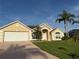 Beautiful one-story home with a two-car garage, manicured lawn, and tropical landscaping at 240 Steamboat Blvd, Davenport, FL 33897