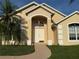Charming front entrance with double doors, decorative transom window, and manicured lawn at 240 Steamboat Blvd, Davenport, FL 33897