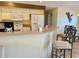 Kitchen view with bar seating and white appliances, plus decorative dragonfly wall art at 240 Steamboat Blvd, Davenport, FL 33897