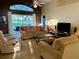 Comfortable living room featuring a sliding glass door with a view of the screened-in pool area at 240 Steamboat Blvd, Davenport, FL 33897