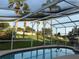 Screened-in backyard pool and landscaping with views of the manicured backyard at 240 Steamboat Blvd, Davenport, FL 33897