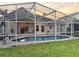 Inviting screened-in pool area for outdoor relaxation, complete with patio seating and a lush green lawn at 240 Steamboat Blvd, Davenport, FL 33897