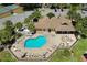 Aerial view of the pool, hot tub, surrounding lounge chairs and tables, and community buildings at 2438 Sweetwater Club Cir # 50, Kissimmee, FL 34746