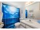 Well-lit bathroom featuring a shower with blue sea-themed curtain and a vanity with a sink at 2438 Sweetwater Club Cir # 50, Kissimmee, FL 34746