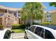 Condo building exterior with brick accents, lush landscaping, and a glimpse of a neighboring yellow building at 2438 Sweetwater Club Cir # 50, Kissimmee, FL 34746