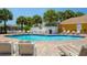 Community pool with lounge chairs, tables, and a well-maintained deck for relaxation and socializing at 2438 Sweetwater Club Cir # 50, Kissimmee, FL 34746