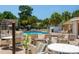 Community pool with lounge chairs and tables surrounded by green trees and manicured landscaping at 2438 Sweetwater Club Cir # 50, Kissimmee, FL 34746