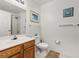 Well-lit bathroom featuring a wood vanity, and a shower with white tile at 2620 Lodi Cir # 103, Kissimmee, FL 34746