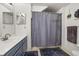 Clean bathroom featuring a shower with a gray curtain, and navy blue cabinets at 2620 Lodi Cir # 103, Kissimmee, FL 34746