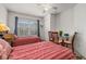 Bedroom featuring two twin beds with red linens, a ceiling fan and a glass table at 2620 Lodi Cir # 103, Kissimmee, FL 34746
